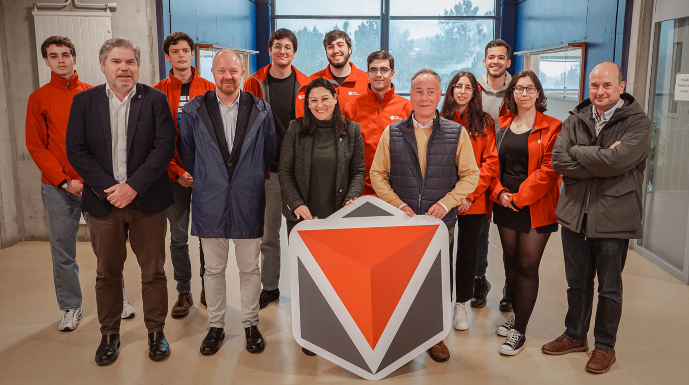 Las personas asistentes al acto institucional posan con el emblema de UVigo SpaceLab en la entrada del edificio Filomena Dato